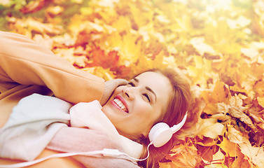 Image showing woman with headphones listening to music in autumn