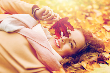 Image showing beautiful happy woman lying on autumn leaves