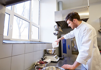 Image showing happy male chef cooking food at restaurant kitchen