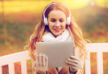 Image showing woman with tablet pc and headphones in autumn park