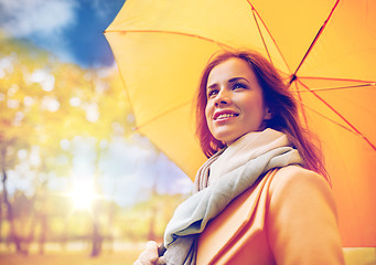 Image showing happy woman with umbrella walking in autumn park