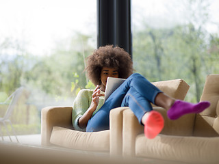 Image showing young african american woman at home using digital tablet