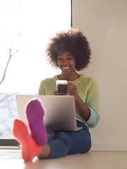 Image showing black woman in the living room on the floor