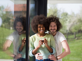 Image showing happy multiethnic couple relaxing at modern home indoors