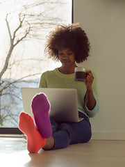 Image showing black woman in the living room on the floor