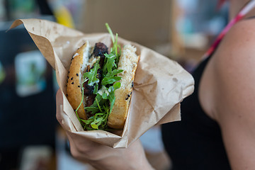 Image showing Woman holding juicy burger in her hands.