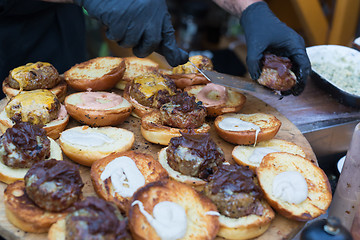 Image showing Chef making beef burgers outdoor on open kitchen international food festival event.