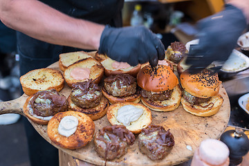 Image showing Chef making beef burgers outdoor on open kitchen international food festival event.