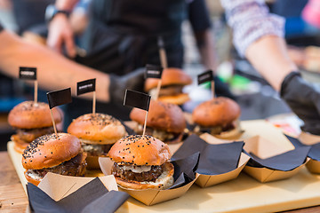 Image showing Chef making beef burgers outdoor on open kitchen international food festival event.