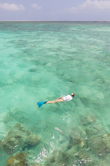 Image showing Woman snorkeling in clear shallow sea of tropical lagoon with turquoise blue water.