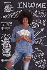 Image showing black woman holding money on gray background