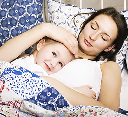 Image showing Portrait of mother and daughter laying in bed and smiling