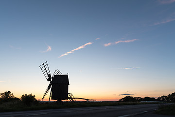 Image showing Wooden windmill silhouette by roadside