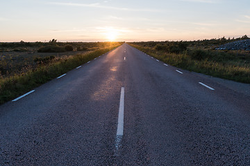 Image showing Straight country road by sunset in an open landscape