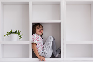 Image showing young boy posing on a shelf