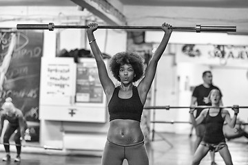 Image showing black woman lifting empty bar