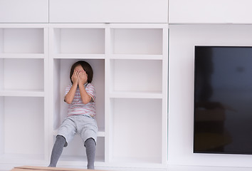 Image showing young boy posing on a shelf