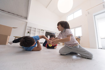 Image showing boys having fun with an apple on the floor