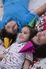 Image showing kids  blowing confetti while lying on the floor