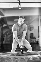 Image showing man workout with hammer and tractor tire