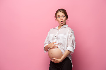 Image showing Young beautiful pregnant woman standing on pink background