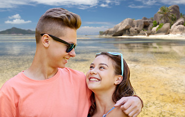 Image showing happy teenage couple hugging at summer beach