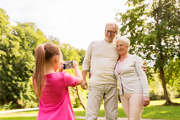 Image showing granddaughter photographing grandparents at park