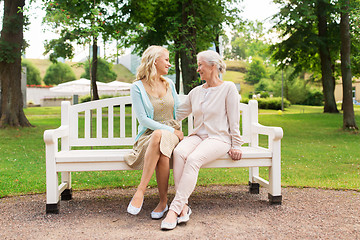 Image showing daughter with senior mother hugging on park bench