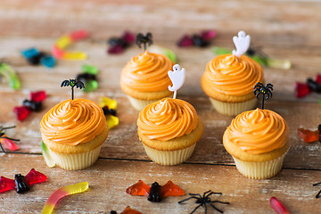 Image showing halloween party decorated cupcakes on wooden table