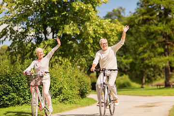 Image showing happy senior couple riding bicycles at park