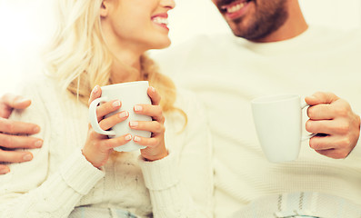 Image showing close up of happy couple with tea cups at home