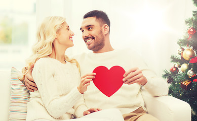 Image showing happy couple with red heart at home for christmas