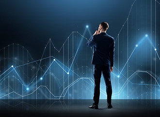 Image showing businessman in suit from back with virtual graph