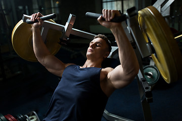 Image showing man doing chest press on exercise machine in gym