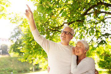 Image showing happy senior couple hugging at summer park