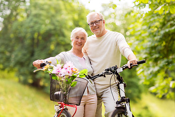 Image showing happy senior couple with bicycles at summer park