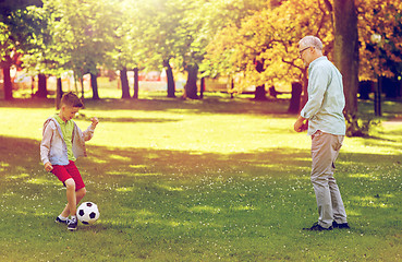 Image showing old man and boy playing football at summer park