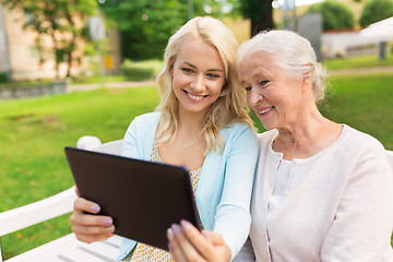 Image showing daughter with tablet pc and senior mother at park