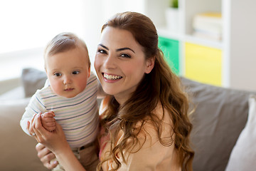 Image showing happy young mother with little baby at home