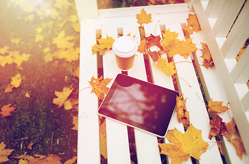 Image showing tablet pc and coffee cup on bench in autumn park