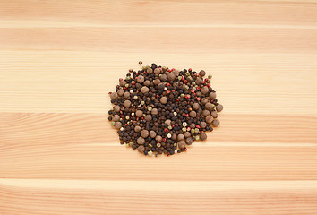 Image showing Mixed peppercorns on wood