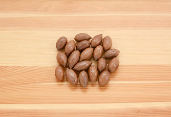 Image showing Pecan nuts in shells on wood