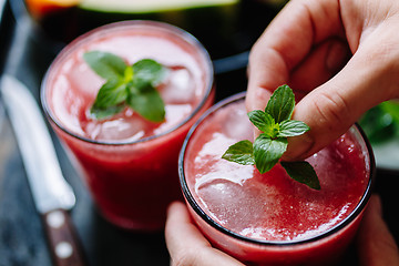 Image showing Person decorates red smoothie