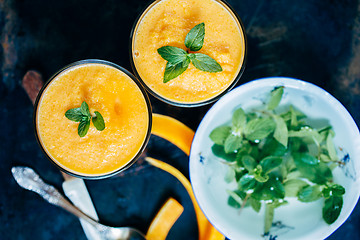 Image showing Orange smoothie with leaves of fresh mint