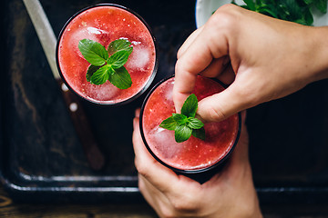 Image showing Person decorates red smoothie