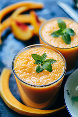 Image showing Orange smoothie with leaves of fresh mint