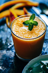 Image showing Orange smoothie with leaves of fresh mint