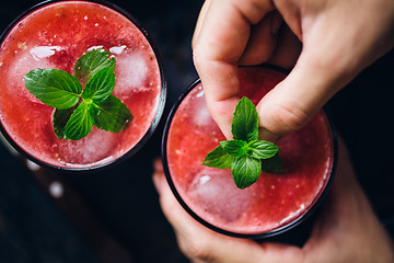 Image showing Person decorates red smoothie