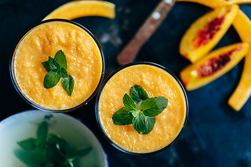 Image showing Orange smoothie with leaves of fresh mint