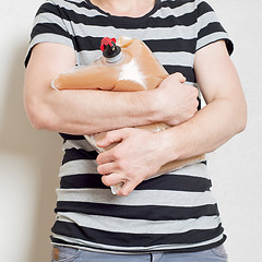 Image showing Man holding plastic bag with tap full of apple juice
